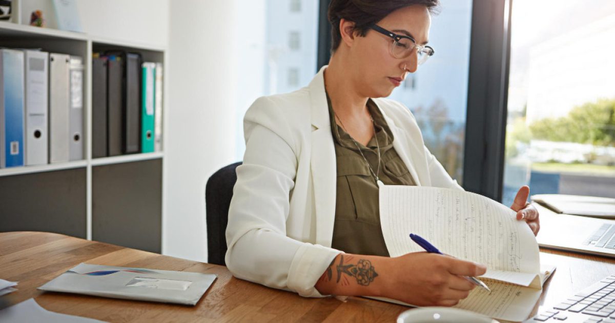Profissional revisando documentos em ambiente de trabalho, representando o processo de tradução juramentada com alto padrão de qualidade